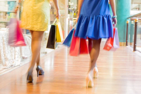 Dos mujeres caminando con bolsas de compras en el centro comercial —  Fotos de Stock