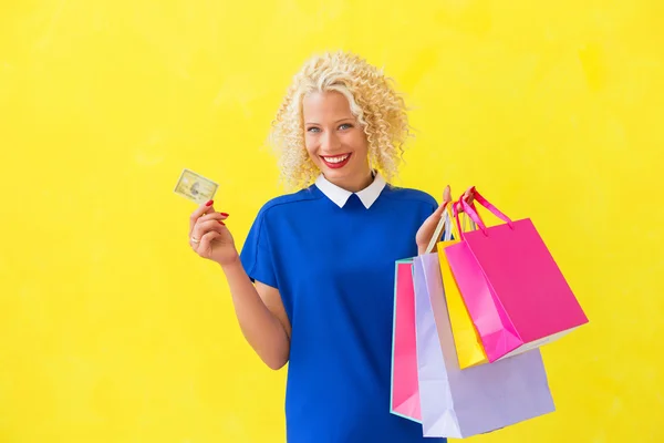 Mujer feliz sosteniendo bolsas de compras y tarjeta de crédito —  Fotos de Stock