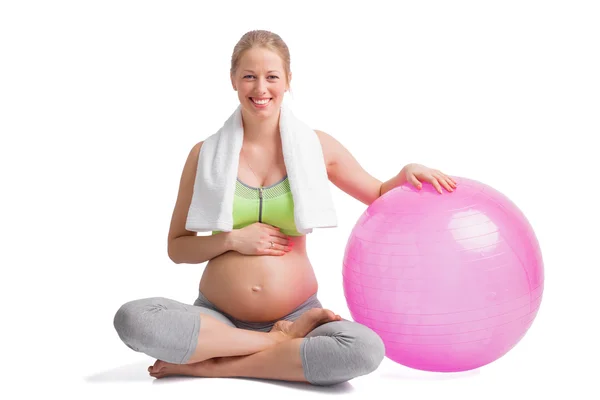 Femme heureuse et enceinte assise en position lotus avec boule de médecine — Photo