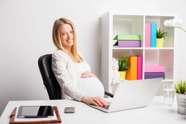 Gelukkig zwangere vrouw, werkzaam in het kantoor — Stockfoto