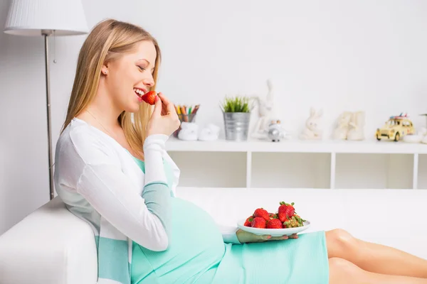 Zwangere vrouw die aardbeien eet — Stockfoto