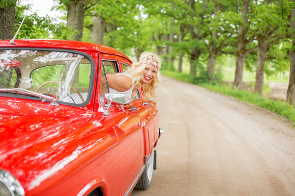 Woman hanging out of retro cars window
