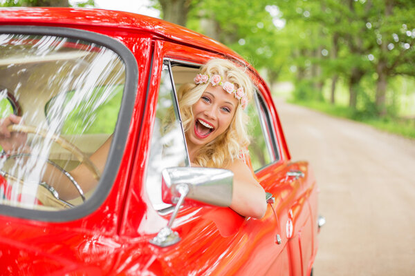 woman enjoying driving a retro car