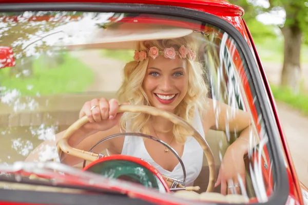 Жінка сидить у сидінні водія в ретро-автомобілі і посміхається — стокове фото