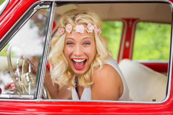 Happy  woman laughing while sitting in retro car
