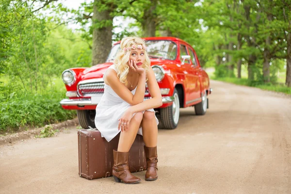 Treurige vrouw zittend op een suitecase en wachten op hulp — Stockfoto