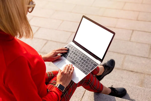 女性が屋外で使用するラップトップコンピュータの空のモックアップ画面 — ストック写真