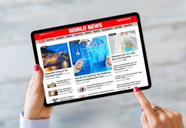 Tablet tutan ve son haberleri internetten okuyan kişi