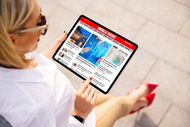 Tabletten en son haberleri okuyan kadın