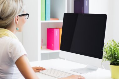 Young creative woman working with computer in the office clipart