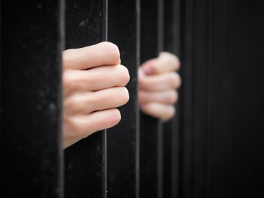 Prisoner behind jail bars clipart