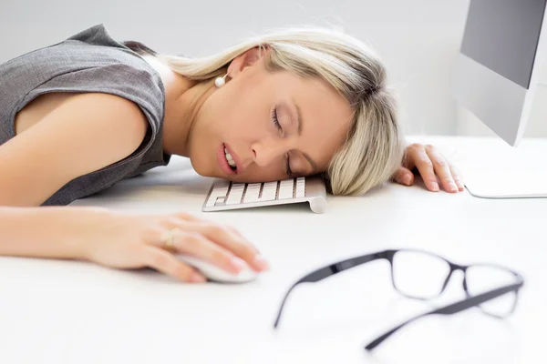 Erschöpfte Frau schläft vor Computer — Stockfoto
