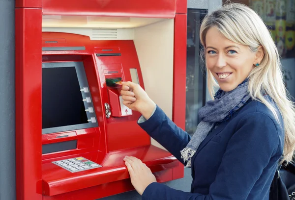 Happy woman using ATM to withdraw money — Stock Photo, Image