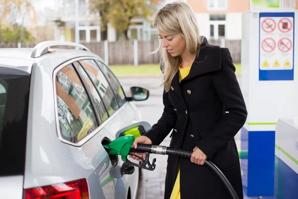 Junge Frau betankt Auto in Tankstelle — Stockfoto