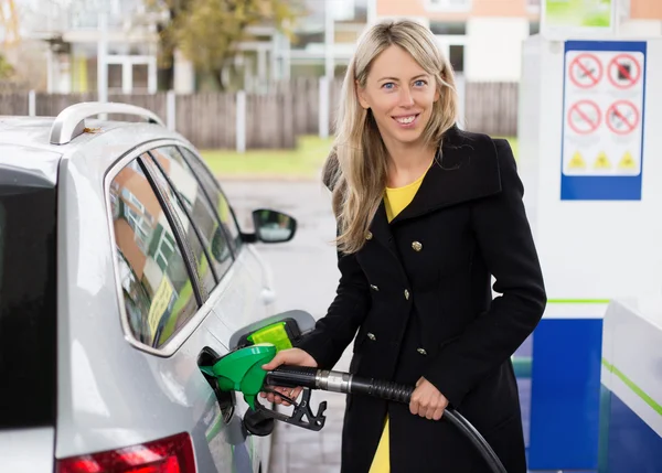 Junge Frau betankt Auto in Tankstelle — Stockfoto