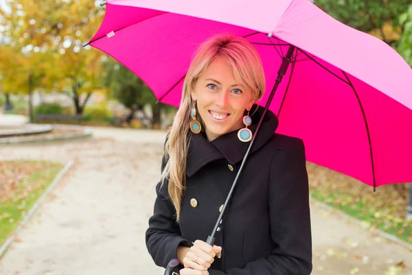 Donna con ombrello rosa godendo autunno — Foto Stock