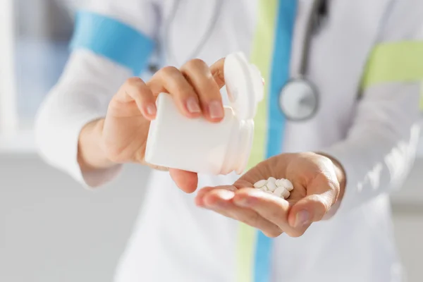 Doutor derramando pílulas de medicina na mão — Fotografia de Stock