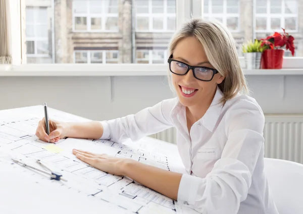 Young female architect sitting at her desk in the office — Stock Photo, Image