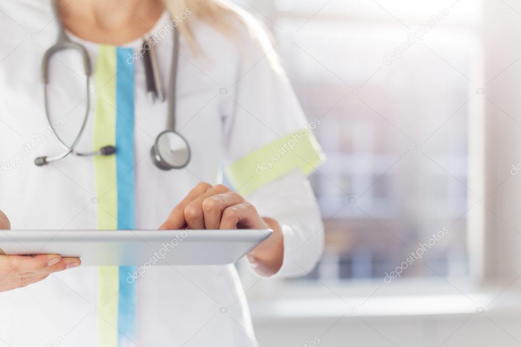 Woman doctor using tablet computer in hospital