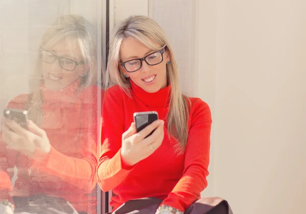 Jonge vrolijke vrouw met behulp van smartphone — Stockfoto