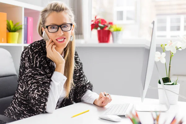 Творческая молодая деловая женщина разговаривает по телефону в офисе — стоковое фото