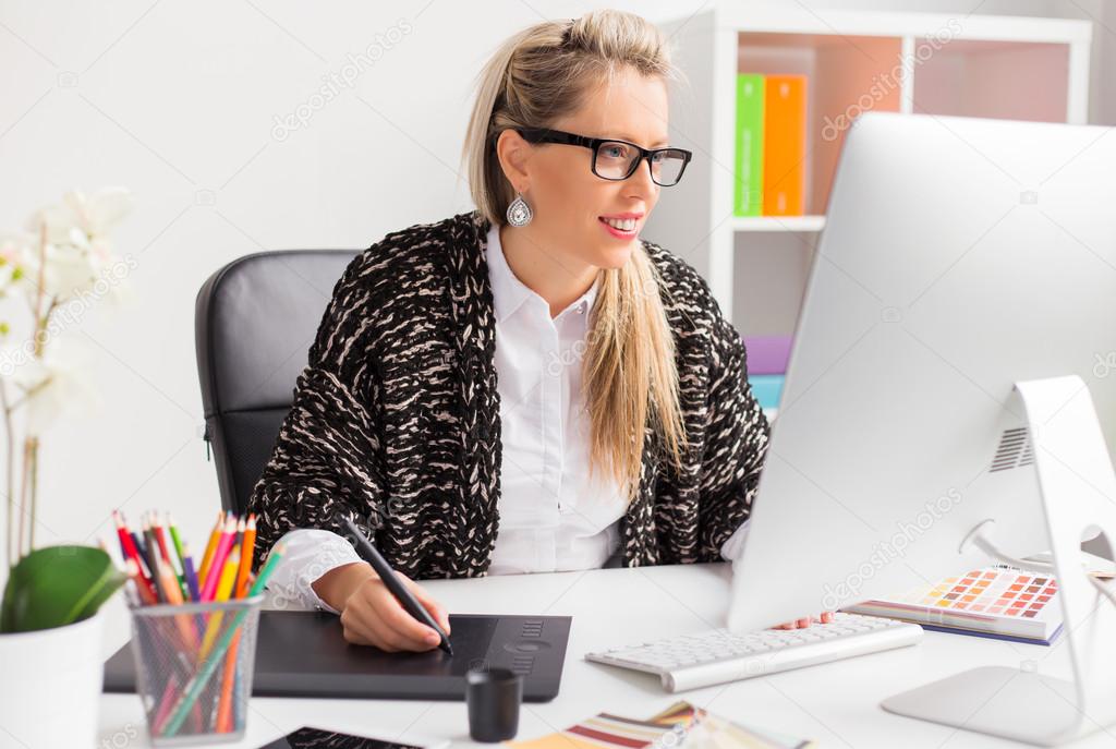 Computer artist using graphics tablet while working with computer