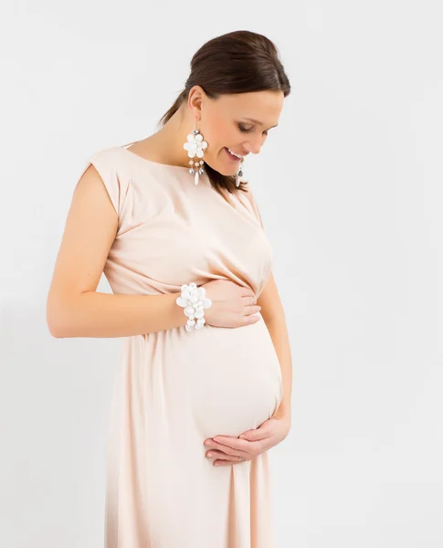 Sorridente donna incinta tenendo la pancia — Foto Stock