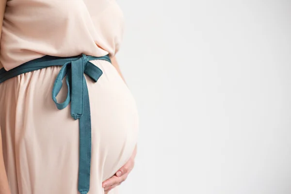 Zwanger vrouw houden haar buik — Stockfoto