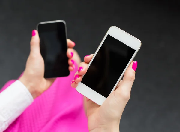Vrouw bedrijf twee mobiele telefoons — Stockfoto