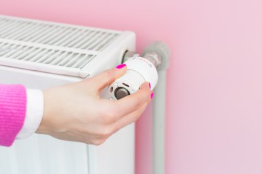Radyatör üzerinde kadın ayarlama termostat