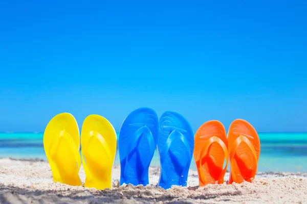 Coloridas sandalias chanclas de playa en la playa — Foto de Stock