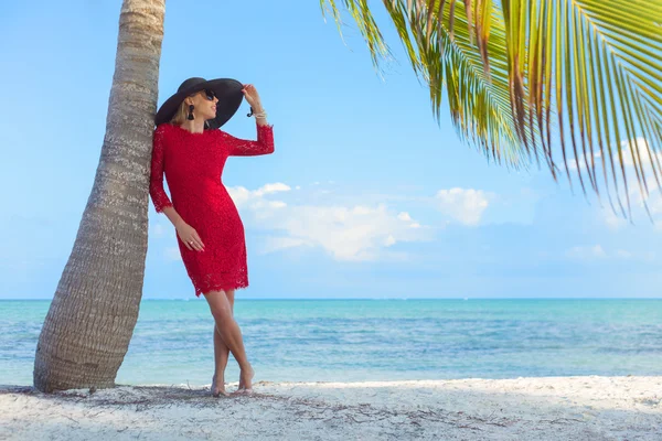 Mladá žena na tropické pláži ve stylu — Stock fotografie