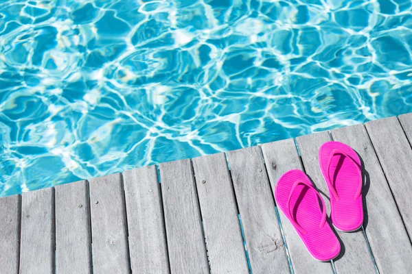 Chanclas rosadas junto a la piscina —  Fotos de Stock