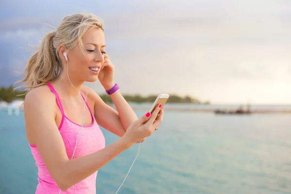 Mujer escuchando música mientras hace ejercicio temprano en la mañana —  Fotos de Stock