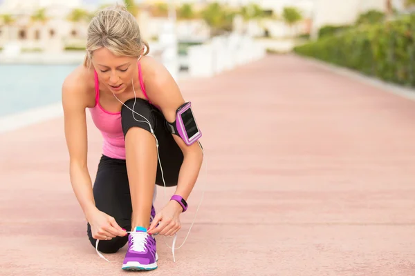 Ajuste mujer atar zapato deportivo antes del ejercicio de la mañana — Foto de Stock