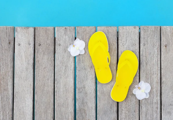 Yellow flip flops by the swimming pool — Stock Photo, Image