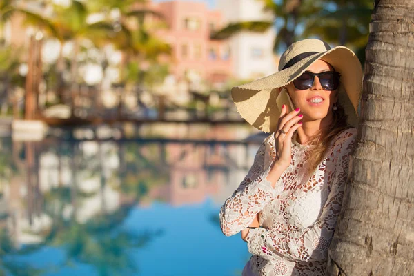 Elegant lady talking on phone while on vacation — Stockfoto