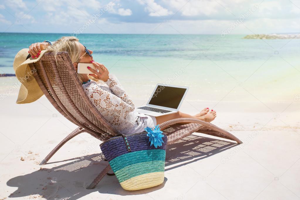 Productive businesswoman working on the beach