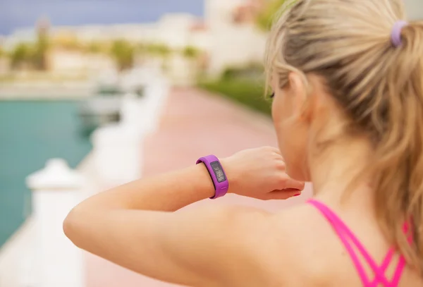 Vrouw op zoek naar haar smartwatch tijdens de training — Stockfoto