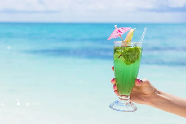 Woman holding glass of fresh mojito cocktail on the beach — Stock Photo, Image