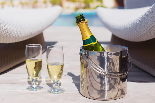 Champagne bottle in bucket and two glasses of champagne — Stock fotografie