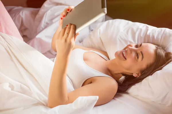 Frau liest E-Book auf digitalem Tablet im Bett — Stockfoto