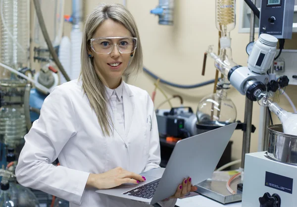 Vrouw met laptop computer werken in chemisch lab — Stockfoto