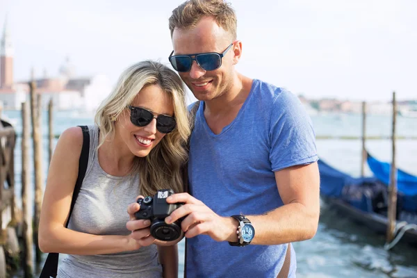 Casal olhando para fotos na parte de trás da câmera digital — Fotografia de Stock