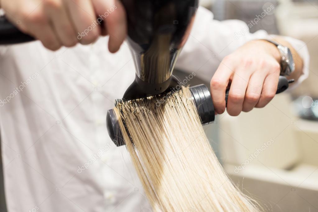 Hairdresser blow drying hair