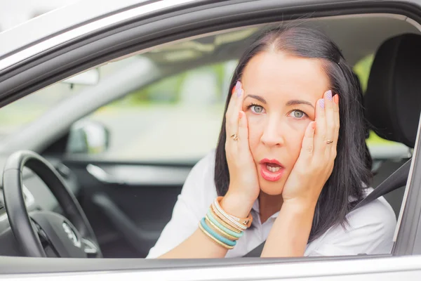 Donna in macchina che tiene la testa nell'orrore — Foto Stock