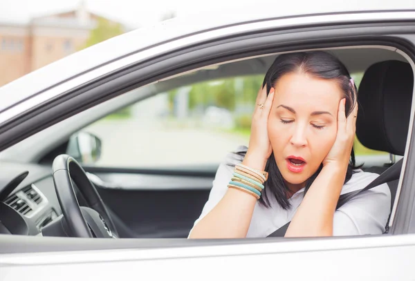 Frau im Auto hält sich vor Schreck den Kopf — Stockfoto