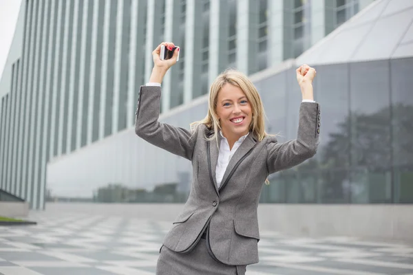 Vrouw met handen omhoog buitenshuis — Stockfoto