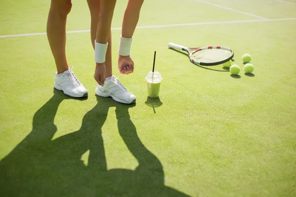 Jogador de tênis amarrando sapatos — Fotografia de Stock