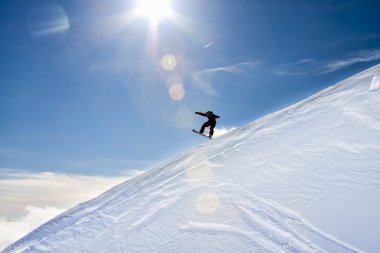 Atlayan bir snowboardcunun silueti..